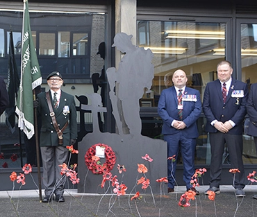 Veterans in front of poppy display